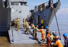 En un esfuerzo mancomunado entre la Armada de Colombia y la Gobernación de La Guajira, en articulación con el Programa Mundial de Alimentos (PMA), el Ejército Nacional, la Policía Nacional, la Cruz Roja Colombiana, la Defensa Civil, el ICBF, entre otras organizaciones, inició hoy la entrega de ayudas en el departamento de La Guajira, afectado por la segunda temporada de lluvias que azota al país en los últimos días. A primeras horas de la mañana emplayó en el sector conocido como “Amas Sai”, en Riohacha, el Buque de Desembarco Anfibio ARC “Golfo de Urabá” para iniciar el embarque de las ayudas que fueron dispuestas, con el fin de brindar asistencia humanitaria a las comunidades afectadas en la Alta Guajira, las cuales permanecen incomunicadas debido a las graves inundaciones de la región. A bordo del ARC “Golfo de Urabá” y de los camiones de Infantería de Marina de la Armada Nacional, que llegarán a siete puntos nodales de la Alta Guajira enfrentando condiciones adversas de tiempo y terreno, se transportarán más de 150 toneladas de elementos de primera necesidad y víveres, entre los que se encuentran alimentos, kits de aseo, agua potable, entre otros. Jairo Aguilar Deluque, gobernador de La Guajira, destacó la importancia de esta operación, señalando que “la unión de esfuerzos entre las instituciones y organizaciones permite atender de manera oportuna a quienes más lo necesitan, llevando esperanza a las comunidades afectadas”. En Riohacha fueron entregadas 2.7 toneladas de arroz gestionadas por la Armada de Colombia ante la Corporación “Minuto de Dios”, para iniciar la atención a los afectados de este municipio. Durante 15 días, el ARC “Golfo de Urabá” y los vehículos del Batallón de Movilidad de Infantería de Marina tendrán la misión de transportar y entregar ayudas humanitarias en Bahía Honda, Bahía Hondita, Castilletes, Karasúa, Puerto Bolívar, Puerto Estrella y Puerto López, con apoyo de 71 integrantes de las diferentes autoridades y entidades. Cabe resaltar que la Institución Naval desde la declaratoria de emergencia realizada por el Gobierno Nacional el pasado domingo 10 de noviembre, se encuentra desplegada con sus capacidades de empleo dual y su equipo humano para brindar apoyo humanitario y asistencia a la autoridad civil, en las comunidades del Caribe que han sido afectadas por este fenómeno. La Armada de Colombia, a través de la Fuerza Naval del Caribe, reitera su compromiso de contribuir a la consolidación territorial y al mejoramiento de la calidad de vida de los habitantes de la región, trabajando de manera articulada con entidades públicas y privadas.