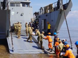 En un esfuerzo mancomunado entre la Armada de Colombia y la Gobernación de La Guajira, en articulación con el Programa Mundial de Alimentos (PMA), el Ejército Nacional, la Policía Nacional, la Cruz Roja Colombiana, la Defensa Civil, el ICBF, entre otras organizaciones, inició hoy la entrega de ayudas en el departamento de La Guajira, afectado por la segunda temporada de lluvias que azota al país en los últimos días. A primeras horas de la mañana emplayó en el sector conocido como “Amas Sai”, en Riohacha, el Buque de Desembarco Anfibio ARC “Golfo de Urabá” para iniciar el embarque de las ayudas que fueron dispuestas, con el fin de brindar asistencia humanitaria a las comunidades afectadas en la Alta Guajira, las cuales permanecen incomunicadas debido a las graves inundaciones de la región. A bordo del ARC “Golfo de Urabá” y de los camiones de Infantería de Marina de la Armada Nacional, que llegarán a siete puntos nodales de la Alta Guajira enfrentando condiciones adversas de tiempo y terreno, se transportarán más de 150 toneladas de elementos de primera necesidad y víveres, entre los que se encuentran alimentos, kits de aseo, agua potable, entre otros. Jairo Aguilar Deluque, gobernador de La Guajira, destacó la importancia de esta operación, señalando que “la unión de esfuerzos entre las instituciones y organizaciones permite atender de manera oportuna a quienes más lo necesitan, llevando esperanza a las comunidades afectadas”. En Riohacha fueron entregadas 2.7 toneladas de arroz gestionadas por la Armada de Colombia ante la Corporación “Minuto de Dios”, para iniciar la atención a los afectados de este municipio. Durante 15 días, el ARC “Golfo de Urabá” y los vehículos del Batallón de Movilidad de Infantería de Marina tendrán la misión de transportar y entregar ayudas humanitarias en Bahía Honda, Bahía Hondita, Castilletes, Karasúa, Puerto Bolívar, Puerto Estrella y Puerto López, con apoyo de 71 integrantes de las diferentes autoridades y entidades. Cabe resaltar que la Institución Naval desde la declaratoria de emergencia realizada por el Gobierno Nacional el pasado domingo 10 de noviembre, se encuentra desplegada con sus capacidades de empleo dual y su equipo humano para brindar apoyo humanitario y asistencia a la autoridad civil, en las comunidades del Caribe que han sido afectadas por este fenómeno. La Armada de Colombia, a través de la Fuerza Naval del Caribe, reitera su compromiso de contribuir a la consolidación territorial y al mejoramiento de la calidad de vida de los habitantes de la región, trabajando de manera articulada con entidades públicas y privadas.